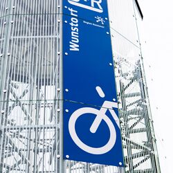 Panneau apposé sur la façade d'un parking à vélos automatisé