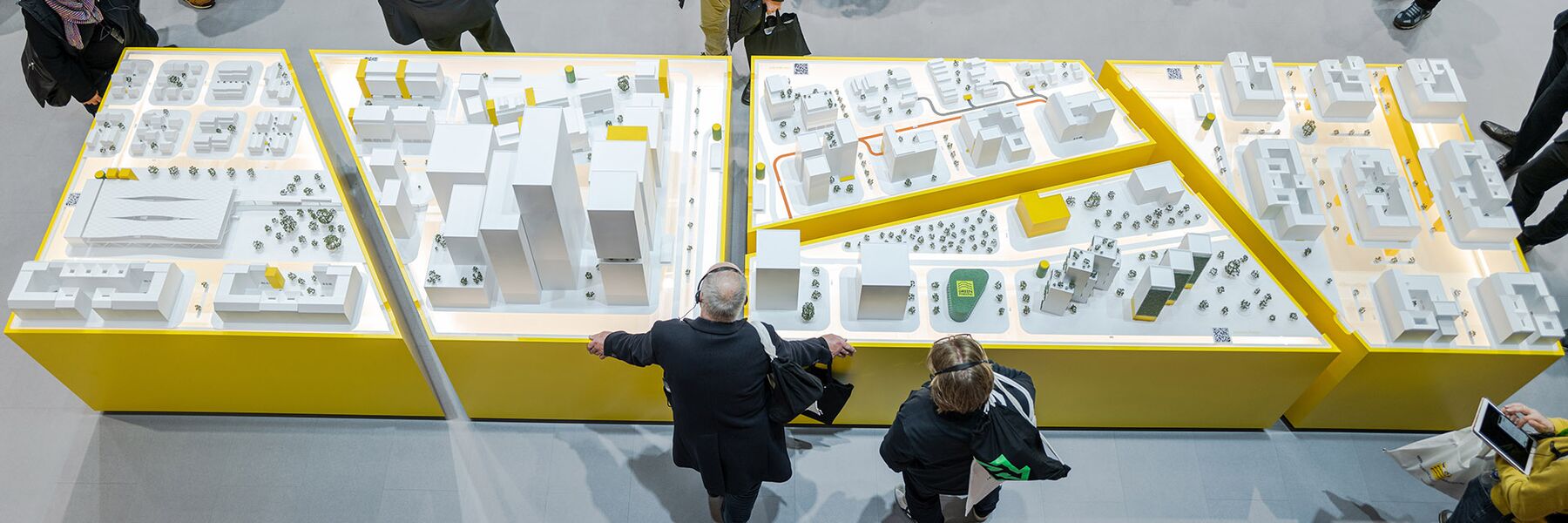 Photo d'une maquette de ville entourée de personnes