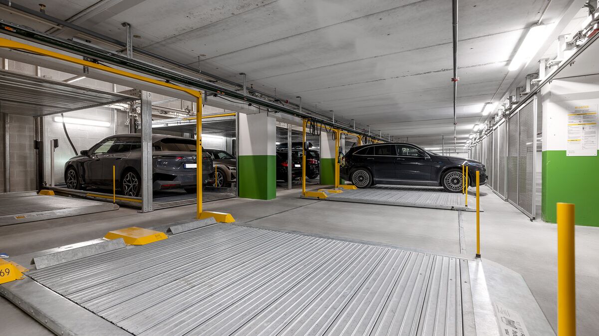 Mehrere Autos stehen auf der Parkplatte in einer Tiefgarage