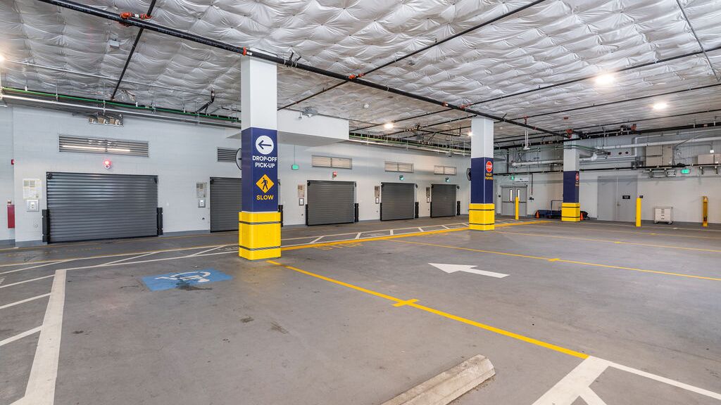 Das Bild zeigt die Einfahrt eines automatisierten Parksystems in einer modernen Tiefgarage mit mehreren Zugangstoren.