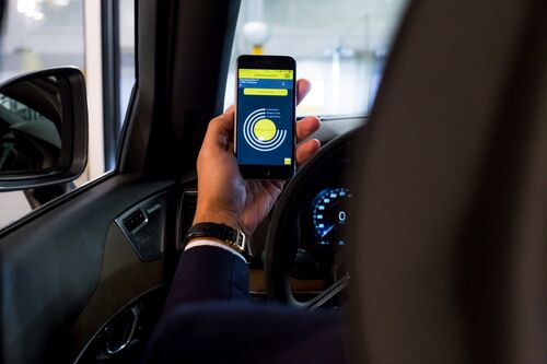 Person hält Handy mit geöffneter App hoch