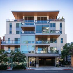 Moderno edificio residenziale con accesso integrato al sistema di parcheggio, ampi balconi e architettura di alta qualità.