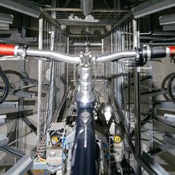 Le vélo est placé dans un rail de guidage au sein d'un système de stationnement