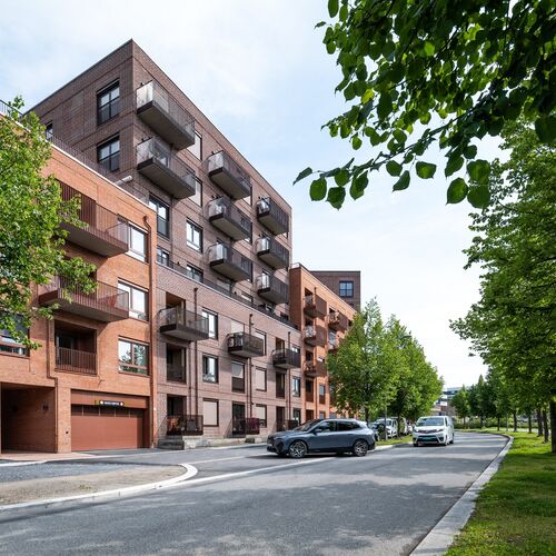 Complesso residenziale moderno in cui un veicolo entra in un garage dotato di un sistema di parcheggio integrato.