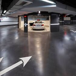 La voiture est garée dans une cabine d'entrée, sur une dalle de stationnement