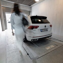 La voiture se trouve dans la cabine d'entrée d'un système de stationnement