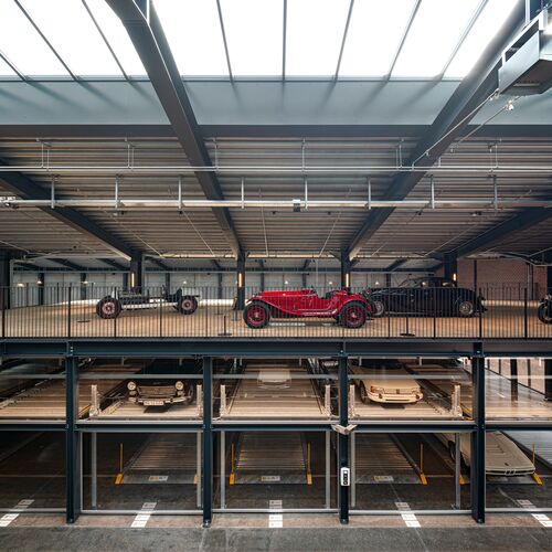 Musée équipé d'un système de stationnement où sont garées des voitures et des voitures de collection