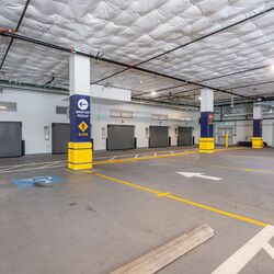 Das Bild zeigt die Einfahrt eines automatisierten Parksystems in einer modernen Tiefgarage mit mehreren Zugangstoren.