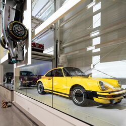 Une voiture de collection jaune garée dans un système de stationnement au sein d'un musée