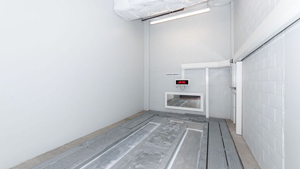Das Bild zeigt den leeren Übergabebereich eines automatisierten Parksystems, in dem Fahrzeuge vor der automatischen Einlagerung positioniert werden.