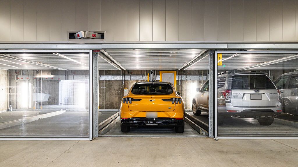 L'immagine mostra un moderno parcheggio sotterraneo con diversi posti auto vetrati di un sistema di parcheggio.