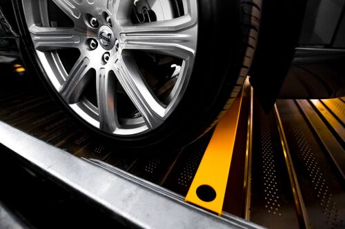 Roue d'une voiture posée sur une dalle de stationnement