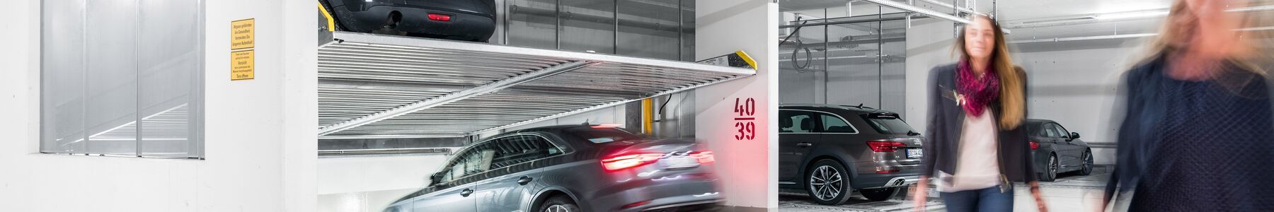 Photo d'un parking souterrain avec des voitures empilées les unes sur les autres dans un système de stationnement