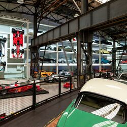 Une étagère murale remplie de voitures dans un musée