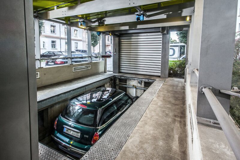 La voiture se trouve dans une cabine d'entrée, sur une plate-forme de stationnement, et descend