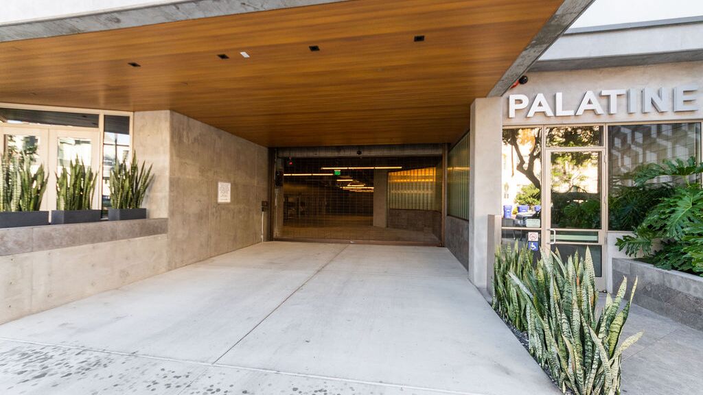 Moderna entrata a un edificio residenziale con sistema di parcheggio integrato.