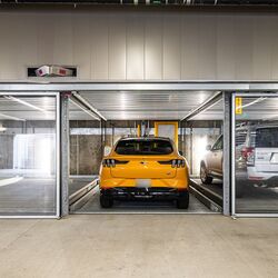 L'immagine mostra un moderno parcheggio sotterraneo con diversi posti auto vetrati di un sistema di parcheggio.