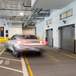 Das Bild zeigt die Einfahrt eines automatisierten Parksystems in einer modernen Tiefgarage mit mehreren Zugangstoren.