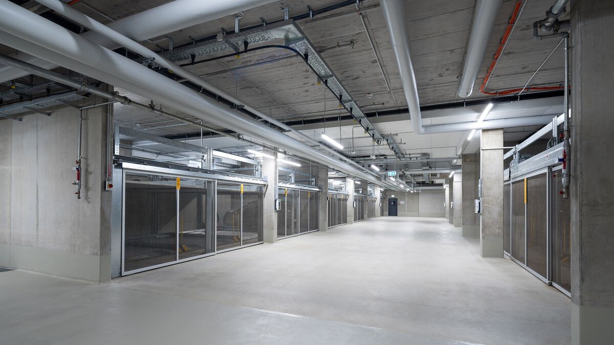 Vue de l'allée dans le parking souterrain entre les systèmes de stationnement latéraux