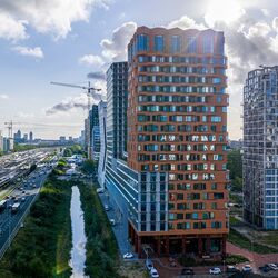 Moderno quartiere urbano con grattacieli, aree verdi e buone infrastrutture.