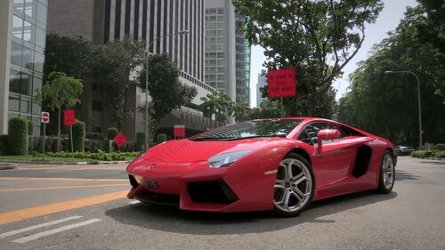 Roter Ferrari der auf der Straße in die Tiefgarage einfährt