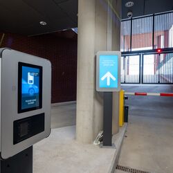 Uscita da un moderno sistema di parcheggio con terminale di accesso, sistema digitale di informazione per i conducenti e barriera automatica.