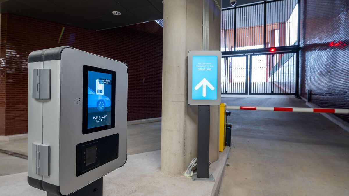 Uscita da un moderno sistema di parcheggio con terminale di accesso, sistema digitale di informazione per i conducenti e barriera automatica.